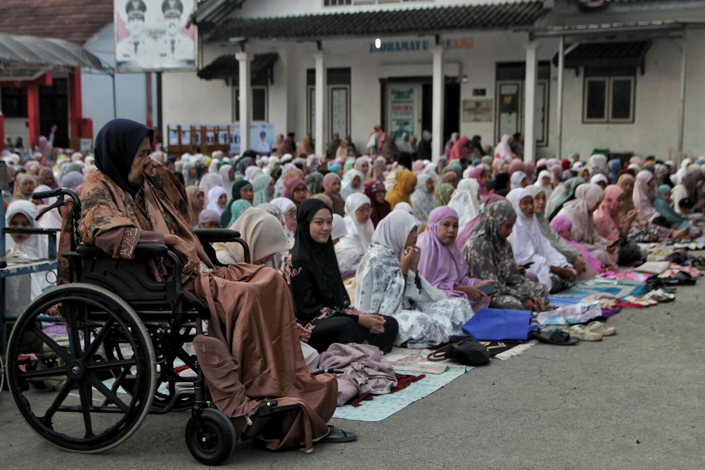 Elderly woman in a wheelchair at a community gathering
